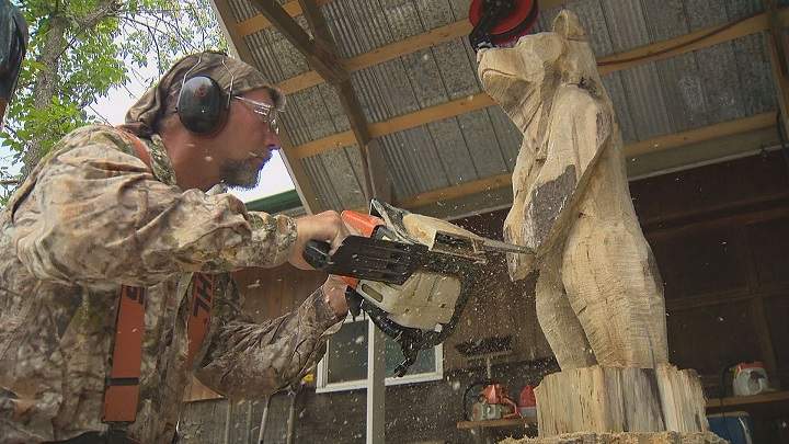 Jim Niedermayer works on a sculpture of a bear while preparing for an upcoming chainsaw carving competition. 