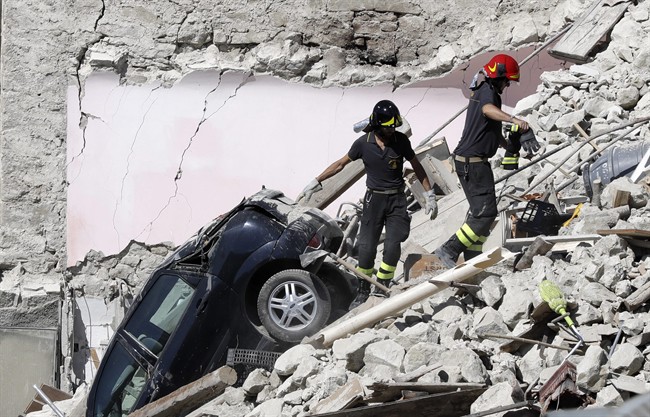 Rescuers make their way through destroyed houses following an earthquake in Italy, in August 2016. Some scientist believe climate change is triggering more earthquakes.