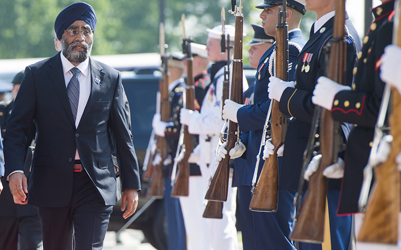 Canadian Defense Minister Harjit Sajjan walks past an honor guard as he arrives to attend a meeting of defense ministers of the Global Coalition to Counter ISIL at Joint Base Andrews in Maryland, July 20, 2016.