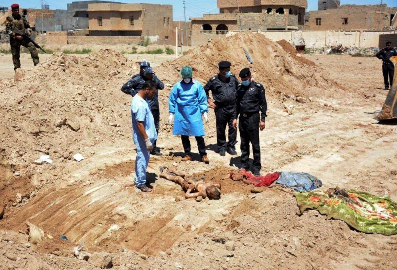 In this April 19, 2016 file photo, an Iraqi security forces forensic team works at the site of a mass grave believed to contain the bodies of Iraqi civilians, security forces and members of their families, including women and children, killed by Islamic State group militants at the stadium area in Ramadi, Iraq. (AP Photo, File)
