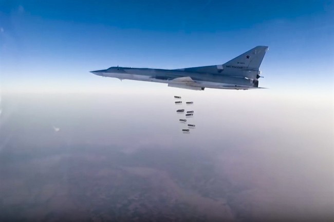 In this frame grab from video provided by the Russian Defence Ministry Press Service, Russian long range bomber Tu-22M3 flies during a strike above an undisclosed location in Syria on Sunday, Aug. 14, 2015.