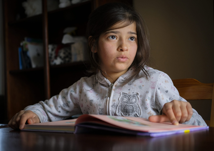 Syrian refugee Rim Younis, 12, practices her English reading skills at her home in Calgary, Alta., .
