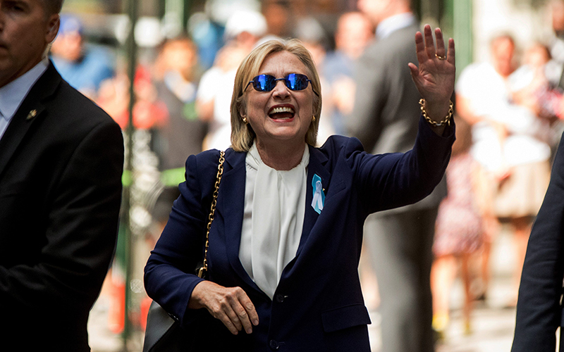 Democratic presidential candidate Hillary Clinton waves after leaving an apartment building Sunday, Sept. 11, 2016, in New York. Clinton's campaign said the Democratic presidential nominee left the 9/11 anniversary ceremony in New York early after feeling "overheated." .