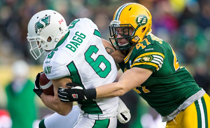 JC Sherritt #47 of the Edmonton Eskimos makes a tackle on Rob Bagg #6 of the Saskatchewan Roughriders in the CFL Western Semi-Final game between the Saskatchewan Roughriders and Edmonton Eskimos at Commonwealth Stadium on November 16, 2014 in Edmonton.