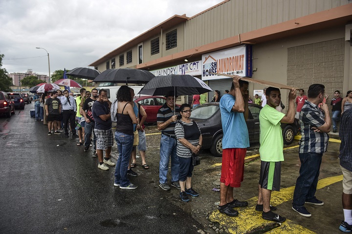 People wait in line to buy ice during a massive blackout in San Juan, Puerto Rico, Thursday, September 22, 2016. Puerto Ricans faced another night of darkness Thursday as crews slowly restored electricity a day after a fire at a power plant caused the aging utility grid to fail and blacked out the entire island.