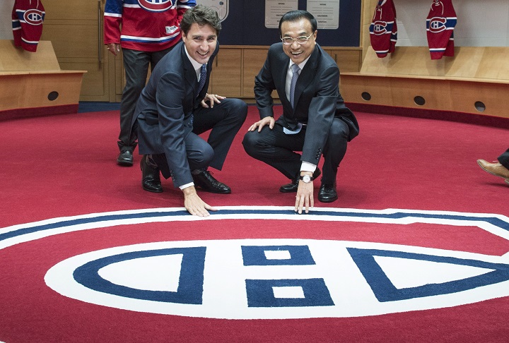 Chinese Premier Li Keqiang, right, and Canadian Prime Minister Justin Trudeau touch the logo of the Montreal Canadiens in the team’s locker room Friday, September 23, 2016 in Montreal.