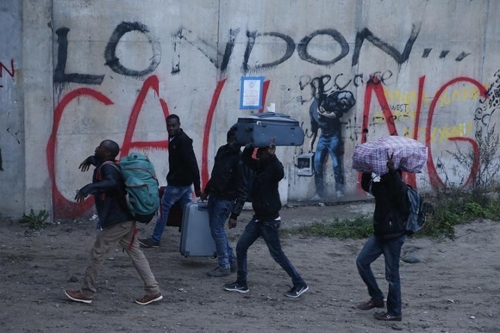 Migrants carry their belongings at the start of their evacuation and transfer to reception centres in France, and the dismantlement of the camp called the “Jungle” in Calais, France, October 24, 2016. REUTERS/Pascal Rossignol