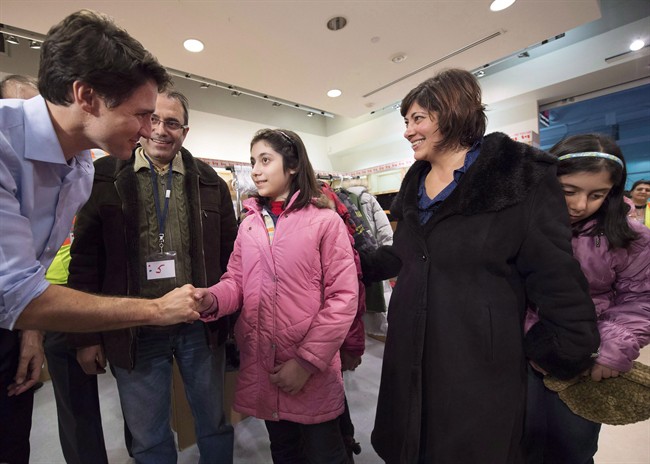 Canadian Prime Minister Justin Trudeau greets newly-arrived Syrian refugees Lucie Garabedian, centre, her father Vanig Garabedian, second left, mother Anjilik Jaghlassian, second right, and sister Anna-Maria Garabedian, right, at Pearson International airport, in Toronto, in a Dec. 11, 2015, file photo.