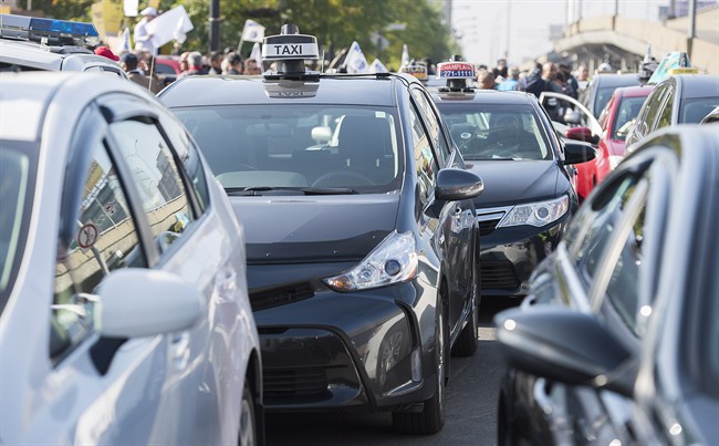 Taxi cabs block a street during a demonstration opposing the presence of Uber in the province of Quebec.
