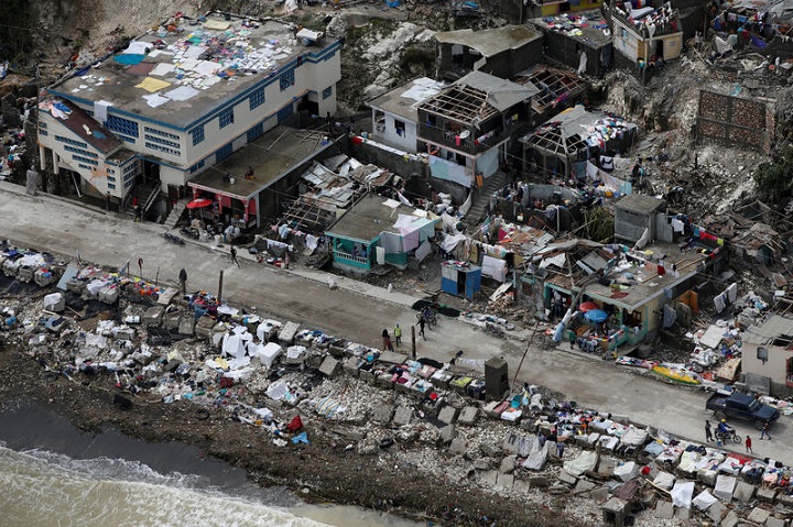 People walk next to destroyed houses after Hurricane Matthew hit Jeremie, Haiti, October 6, 2016. REUTERS/Carlos Garcia Rawlins