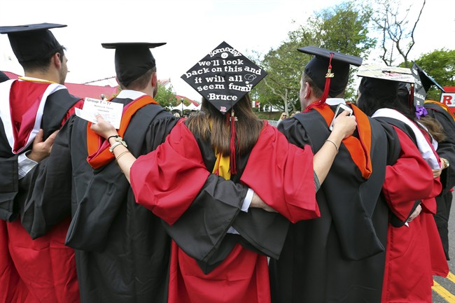 In this May 15, 2016 file photo, students embrace as they arrive for the Rutgers graduation ceremonies in Piscataway, N.J.