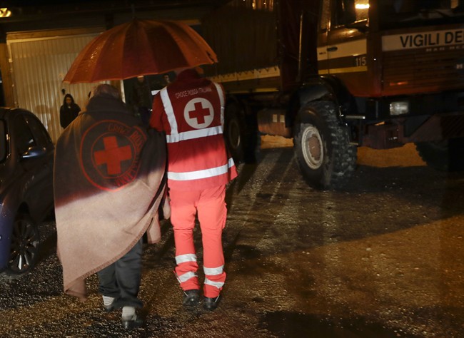 Residents of the small town of Visso in central Italy, early Thursday, Oct 27, 2016, are assisted by the Italian red Cross after a 5.9 earthquake destroyed part of their neighborhood. A pair of strong aftershocks shook central Italy late Wednesday, crumbling churches and buildings, knocking out power and sending panicked residents into the rain-drenched streets just two months after a powerful earthquake killed nearly 300 people. (AP Photo/Alessandra Tarantino).