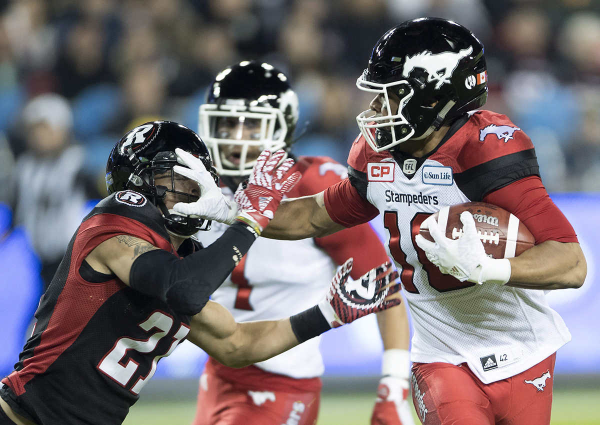 Calgary Stampeders slotback Marquay McDaniel fends off Ottawa Redblacks cornerback Mitchell White during first quarter CFL Grey Cup action, Sunday, November 27, 2016 in Toronto. 