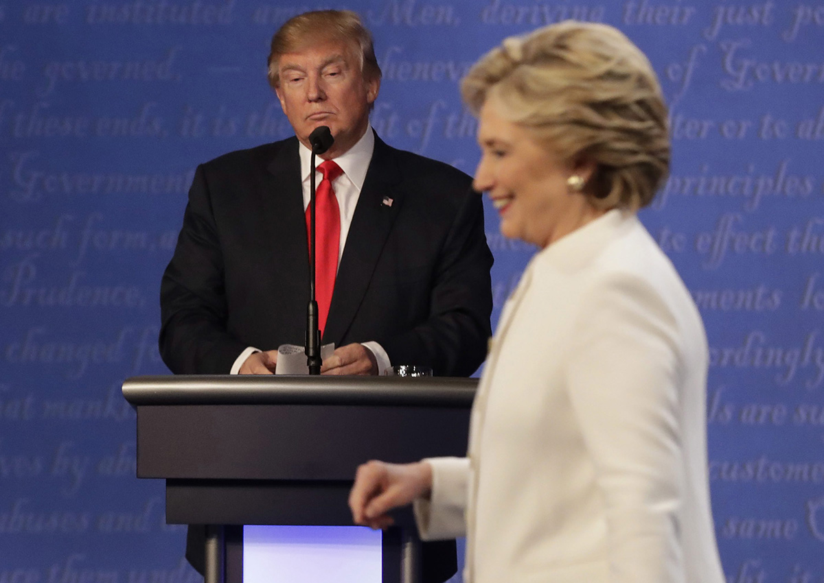 In this Oct. 19, 2016 file photo, Republican presidential nominee Donald Trump waits behind his podium as Democratic presidential nominee Hillary Clinton makes her way off the stage following the third presidential debate at UNLV in Las Vegas. 