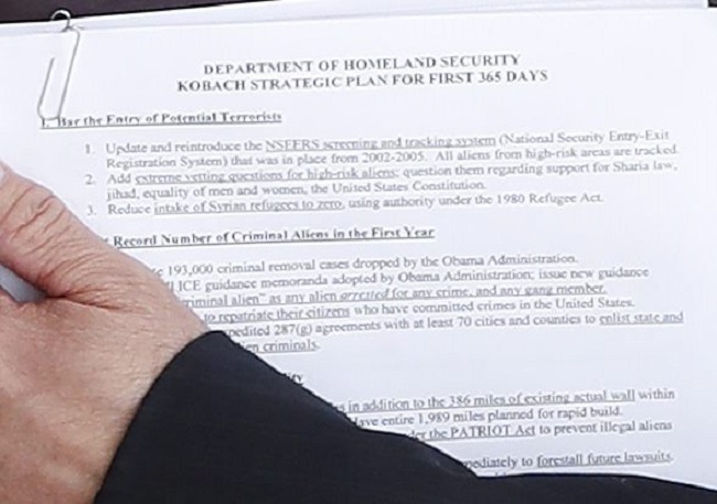 President-elect Donald Trump and Kansas Secretary of State, Kris Kobach, meet at the Trump National Golf Club Bedminster clubhouse, Sunday, Nov. 20, 2016, in Bedminster, N.J.. The documents Kobach is holding offers a glimpse of his plan for the Department of Homeland Security.