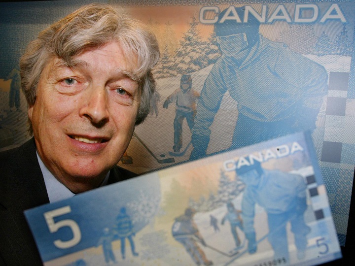 Author Roch Carrier poses with a new Canadian five dollar bill during an unveiling ceremony in Montreal, Wednesday, March 27, 2002. Excerpts from Carrier’s book, The Hockey Sweater, appears on a background of various scenes of children at play. (CP PHOTO/Paul Chiasson)