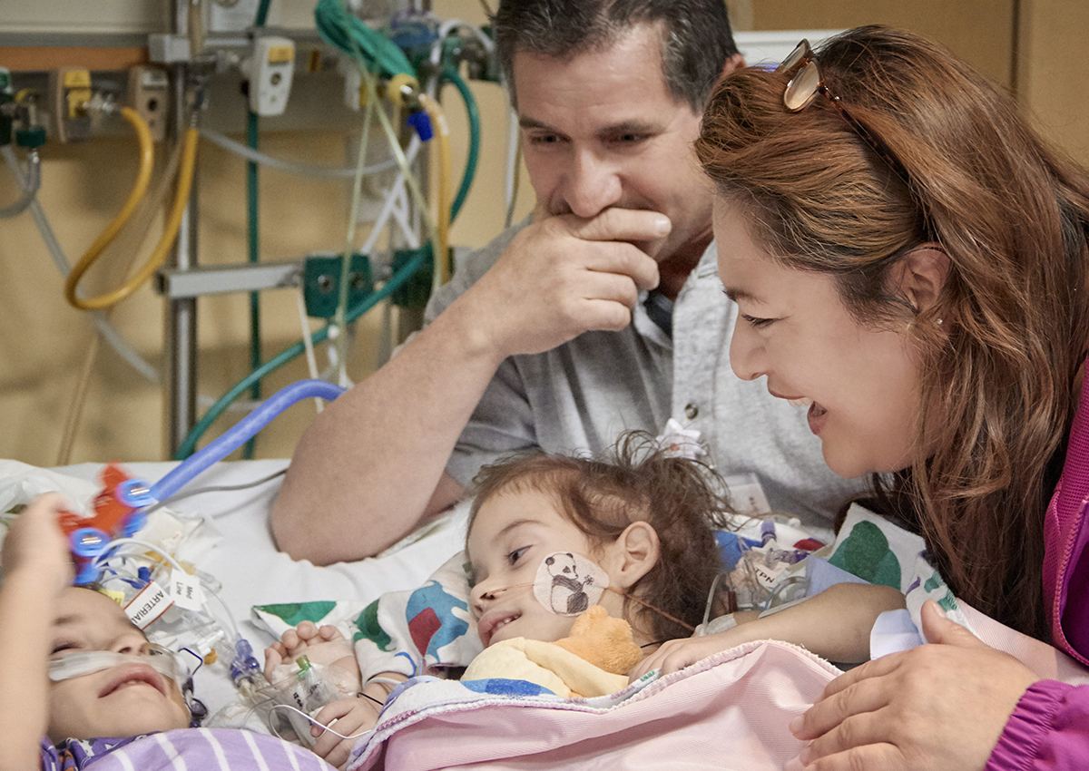 In this Monday, Dec. 12, 2016, photo provided by the Lucile Packard Children's Hospital Stanford, the formerly conjoined twin girls, Eva, left, and Erika, right, reunite for the first time since separation surgery with their parents, Arturo Sandoval and his wife, Aida, in Palo Alto, Calif.
