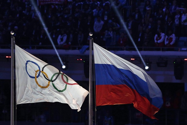 The Russian national flag, right, flies next to the Olympic flag during the closing ceremony of the 2014.THE CANADIAN PRESS/AP, Matthias Schrader.