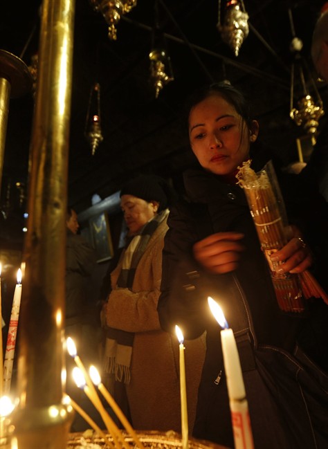 Christian worshippers light candles in the Church of the Nativity, built atop the site where Christians believe Jesus Christ was born, on Christmas Eve, in the West Bank City of Bethlehem, Saturday, Dec. 24, 2016. 