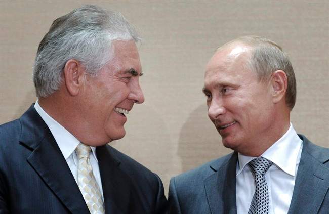 In this Aug. 30, 2011, file photo, Russian Prime Minister Vladimir Putin, right, and Rex Tillerson, ExxonMobil\’s chief executive smile during a signing ceremony in the Black Sea resort of Sochi, Russia.