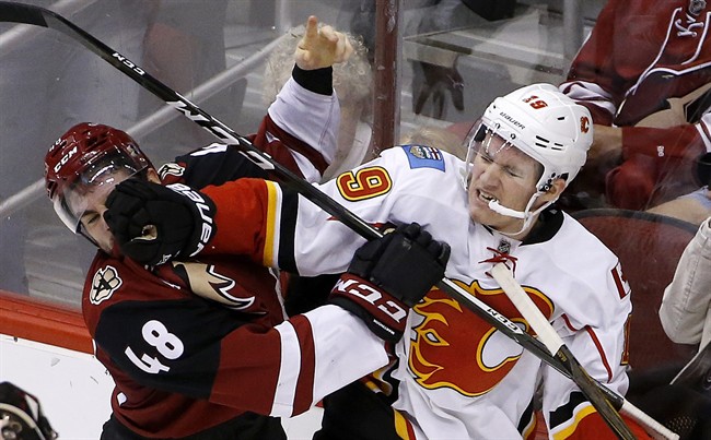 Calgary Flames left wing Matthew Tkachuk (19) mixes it up with Arizona Coyotes left wing Jordan Martinook (48) during the second period of an NHL hockey game Thursday, Dec. 8, 2016, in Glendale, Ariz.