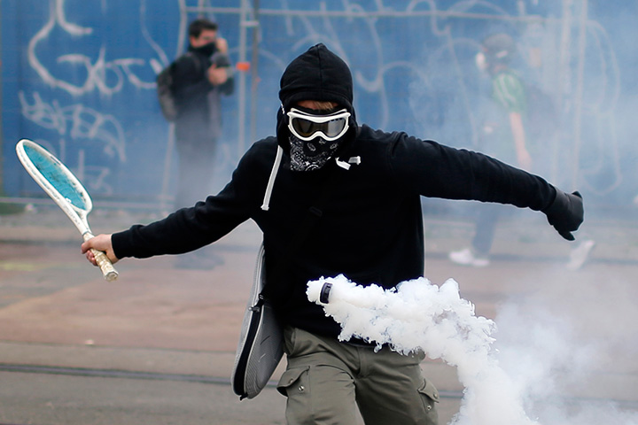 A protester uses a tennis racket to return a tear gas canister at a demonstration against the French government’s proposed labour law reforms in Nantes on June 2, 2016.
