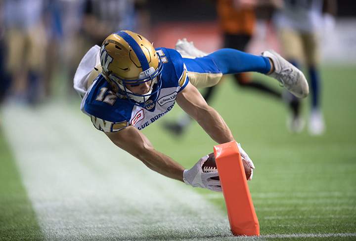 Winnipeg Blue Bombers Ryan Smith dives for the goal line to score his second touchdown against the B.C. Lions during first half western semifinal football action in Vancouver, B.C., on Nov. 13, 2016.