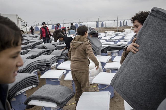Iraqis displaced from Mosul receive aid distributions at near Qayara, Iraq on Wednesday, Dec. 28, 2016. (AP Photo/Cengiz Yar).