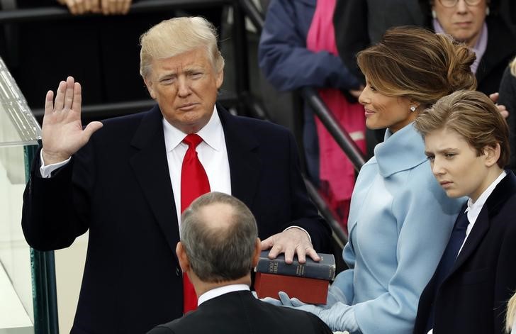 US President Donald Trump takes the oath of office with his wife Melania and son Barron at his side, during his inauguration at the U.S. Capitol in Washington, U.S., January 20, 2017.