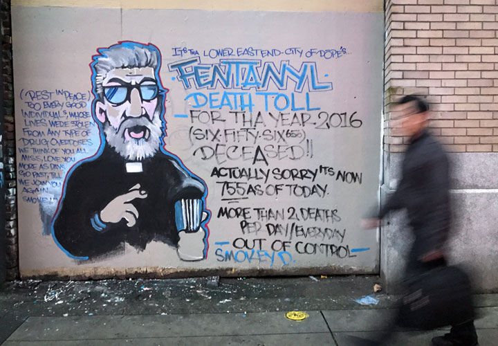 A man walks past a mural about the fentanyl and opioid overdose crisis