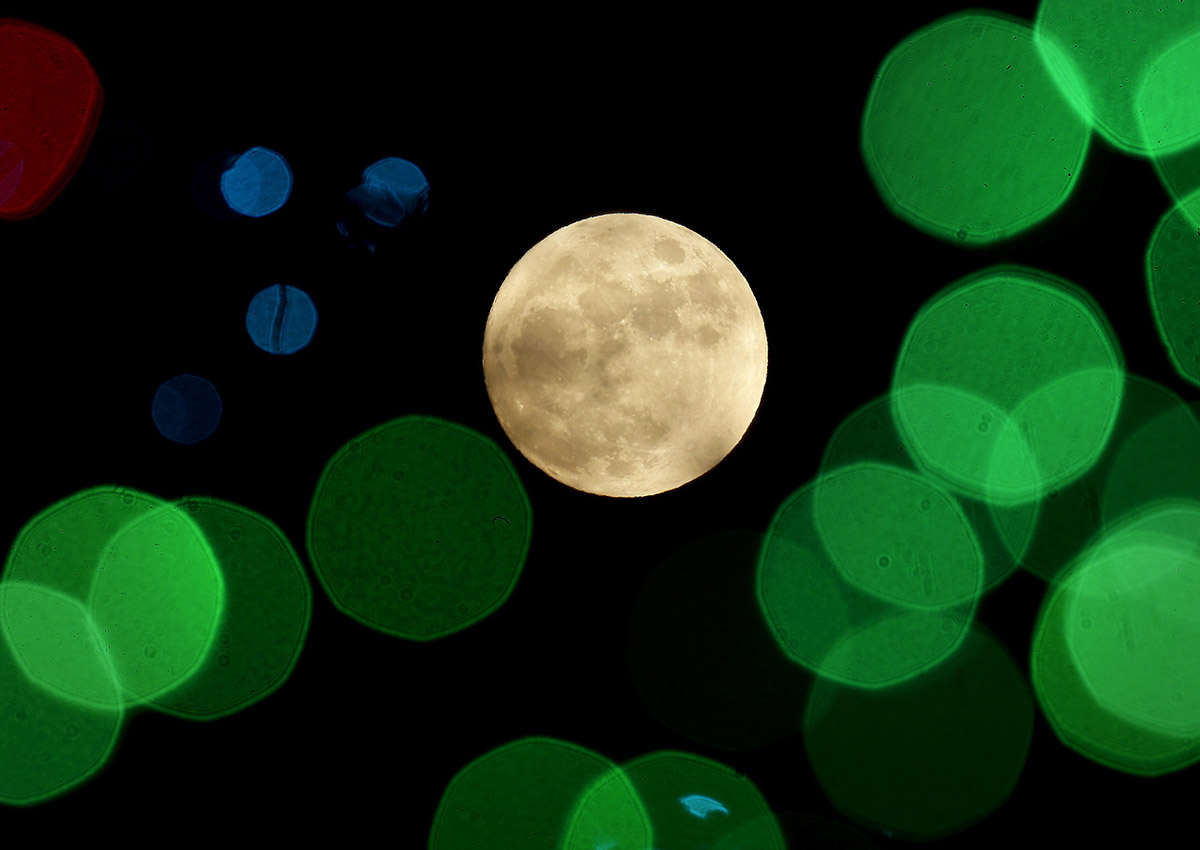  In this Thursday, Dec. 24, 2015, file photo, a nearly-full moon is seen among Christmas lights at a holiday display near Lenexa, Kan. 