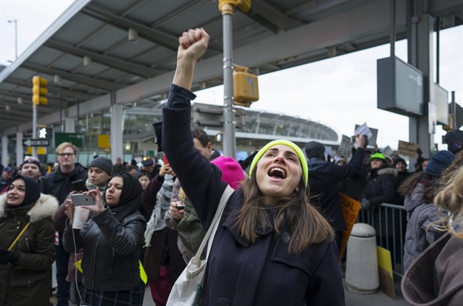 A protester raises her fist and shouts as she joins others assembled at John F. Kennedy International Airport in New York, Saturday, Jan. 28, 2017 after two Iraqi refugees were detained while trying to enter the country. On Friday, Jan. 27, President Donald Trump signed an executive order suspending all immigration from countries with terrorism concerns for 90 days. Countries included in the ban are Iraq, Syria, Iran, Sudan, Libya, Somalia and Yemen, which are all Muslim-majority nations. (AP Photo/Craig Ruttle).