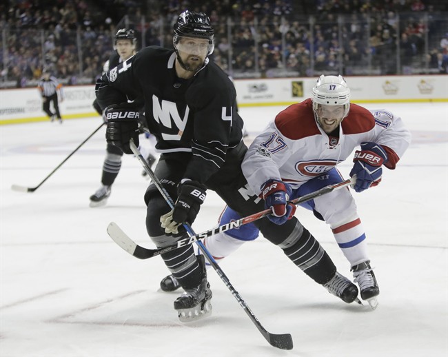 Montreal Canadiens' Torrey Mitchell (17) and New York Islanders' Dennis Seidenberg (4) fight for position during the first period of an NHL hockey game Thursday, Jan. 26, 2017, in New York.