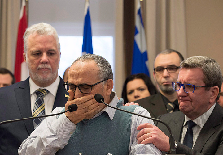Mohamed Labidi, president of the Islamic cultural centre, is comforted by Quebec Premier Philippe Couillard, left, and Quebec City mayor Regis Labeaume, right, during a news conference about the deadly shooting at a mosque in Quebec City on Monday, January 30, 2017.