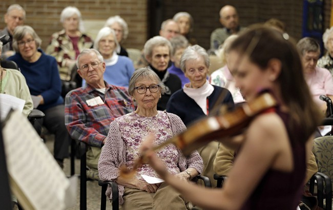 In this Thursday, Feb. 16, 2017 photo, residents watch Nina Sandberg play violin at Judson Park, in Cleveland Heights, Ohio. 