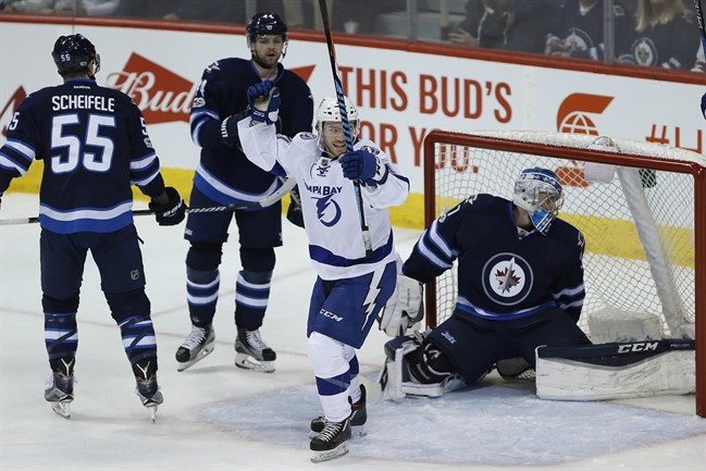Tampa Bay Lightning centre Brayden Point (21) celebrates his goal on Winnipeg Jets goalie Connor Hellebuyck (37) as centre Mark Scheifele (55) and defenceman Josh Morrissey (44) defend during first period NHL action in Winnipeg on Saturday, February 11, 2017.