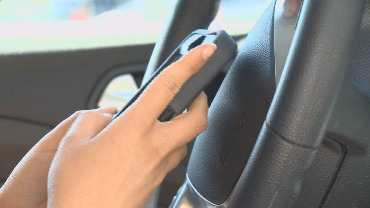 File: A photo of a person distracted while driving.
