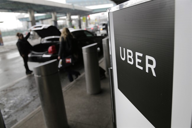 File- In this March 15, 2017, file photo, a sign marks a pick-up point for the Uber car service at LaGuardia Airport in New York.