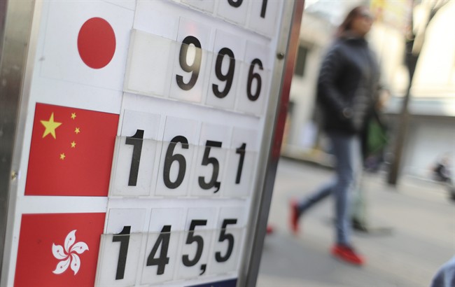 In this March 16, 2017 photo, a visitor walks by signs displaying foreign currency exchange rates between South Korea and China, center and other Asia countries in downtown Seoul, South Korea. 