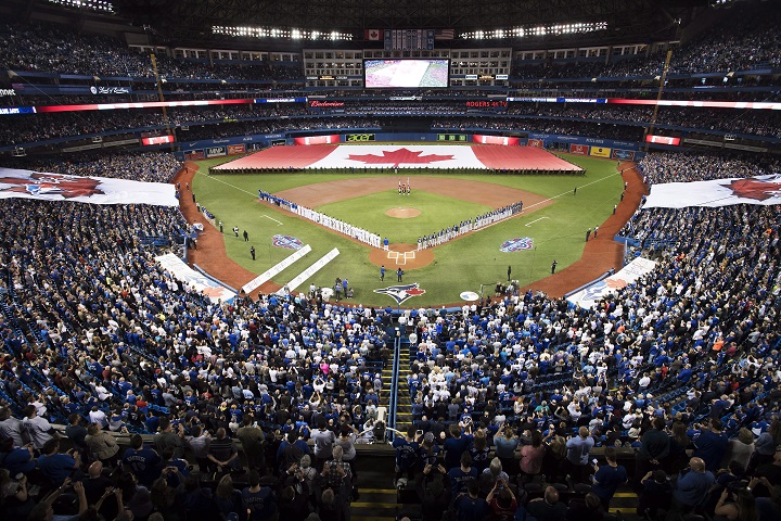 Toronto Blue Jays and Milwaukee Brewers players stand for the national anthems prior to interleague baseball action in Toronto, Tuesday, April 11, 2017.