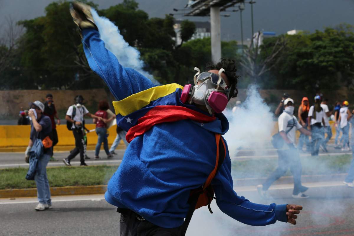 A demonstrator returns a canister of tear gas towards security forces during anti-government protests in Caracas, Venezuela, Wednesday, April 19, 2017. Tens of thousands of opponents of President Nicolas Maduro flooded the streets of Caracas in what’s been dubbed the “mother of all marches” against the embattled socialist president. (AP Photo/Fernando Llano)
