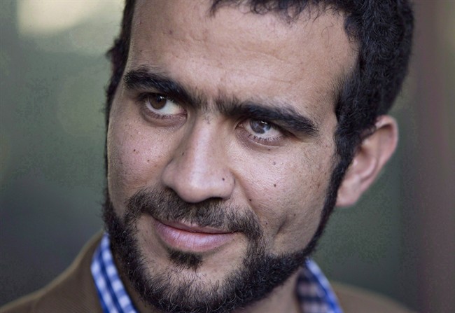 Omar Khadr watches as his lawyer Dennis Edney speaks to media after his bail conditions hearing in Edmonton on Friday, September 11, 2015. Khadr's official criminal record in Canada contains oddities and errors that are at odds with how the federal government viewed him on his return from the notorious prison on the U.S. naval base at Guantanamo Bay, Cuba. 
