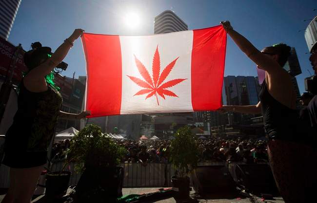 Two people hold a modified design of the Canadian flag with a marijuana leaf in place of the maple leaf during the “420 Toronto” rally in Toronto, April 20, 2016.