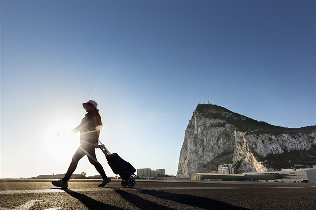 A woman walks on the Spanish side of the border between Spain and the British overseas territory of Gibraltar, on Wednesday, March 1, with the iconic Rock of Gibraltar in the background, in La Linea de la Concepcion, Southern Spain.