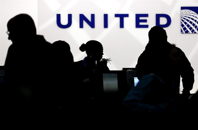 In this Saturday, Dec. 21, 2013, file photo, travelers check in at the United Airlines ticket counter at Terminal 1 in O’Hare International Airport in Chicago.