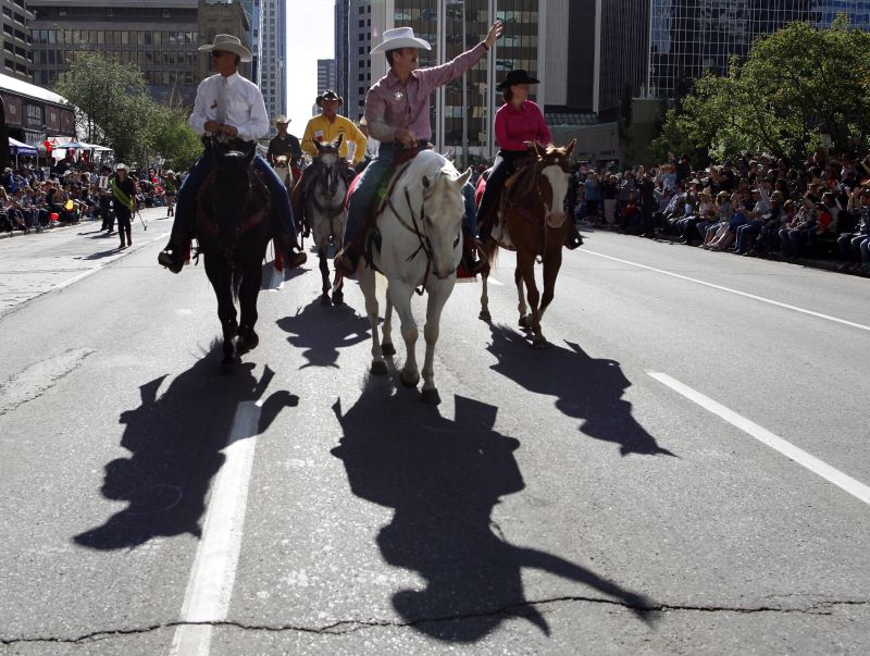 Calgary Stampede parade marshal and astronaut Chris Hadfield, centre, waves to the crowds during the Calgary Stampede parade in Calgary, Friday, July 5, 2013.