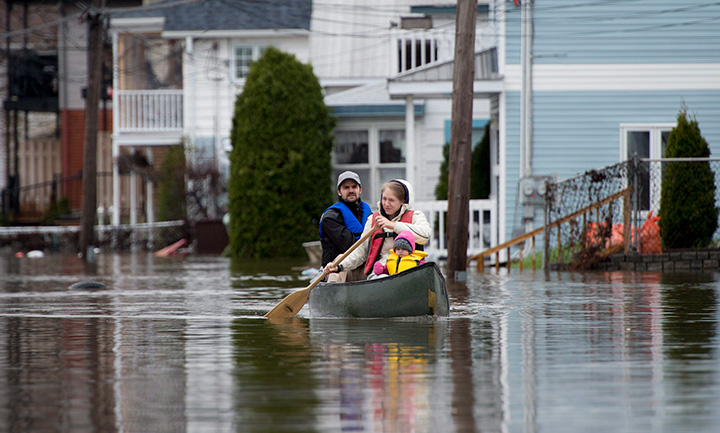 People paddle a canoe through the floodwaters, Sunday May 7, 2017 in Gatineau, Que.