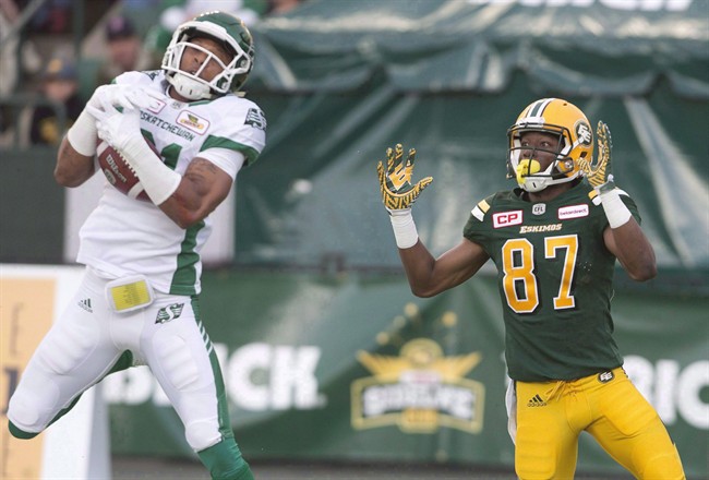 Saskatchewan Roughriders' Justin Cox makes an interception on Edmonton Eskimos' Derel Walker.