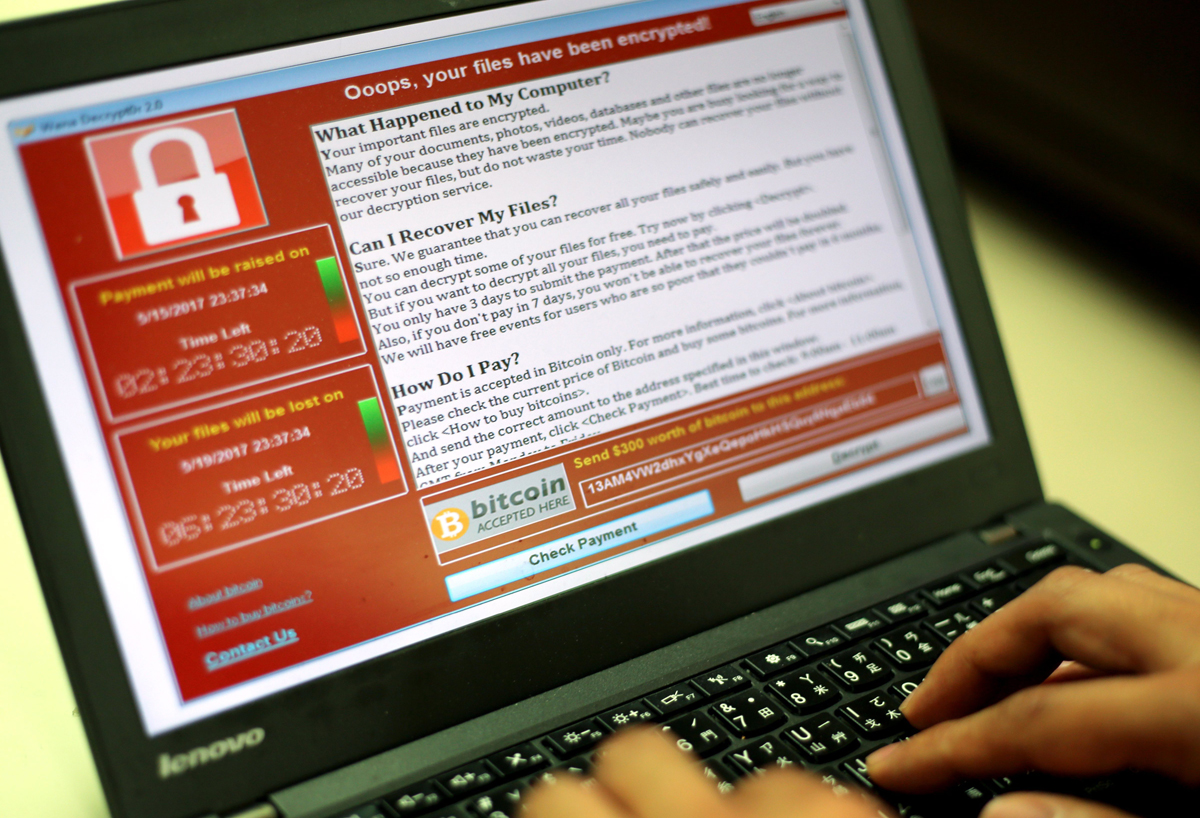 A programmer shows a sample of a ransomware cyberattack on a laptop.