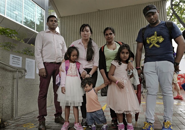 Asylum seekers, from left: Ajith Pushpa Kumara, Vanessa Mae Rodel and her daughter Keana, Nadeeka Dilrukshi Nonis and her son Dinath and daughter Sethmundi Kellapatha, and Supun Thilina Kellapatha, pose outside the building of Hong Kong\’s immigration department in Hong Kong